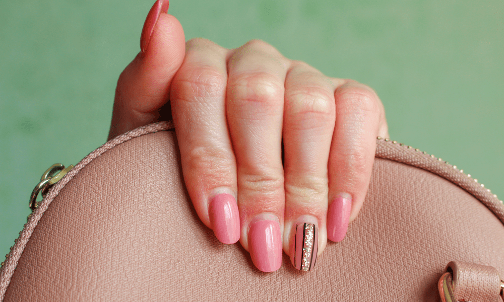 acrylic nails hand holding a purse