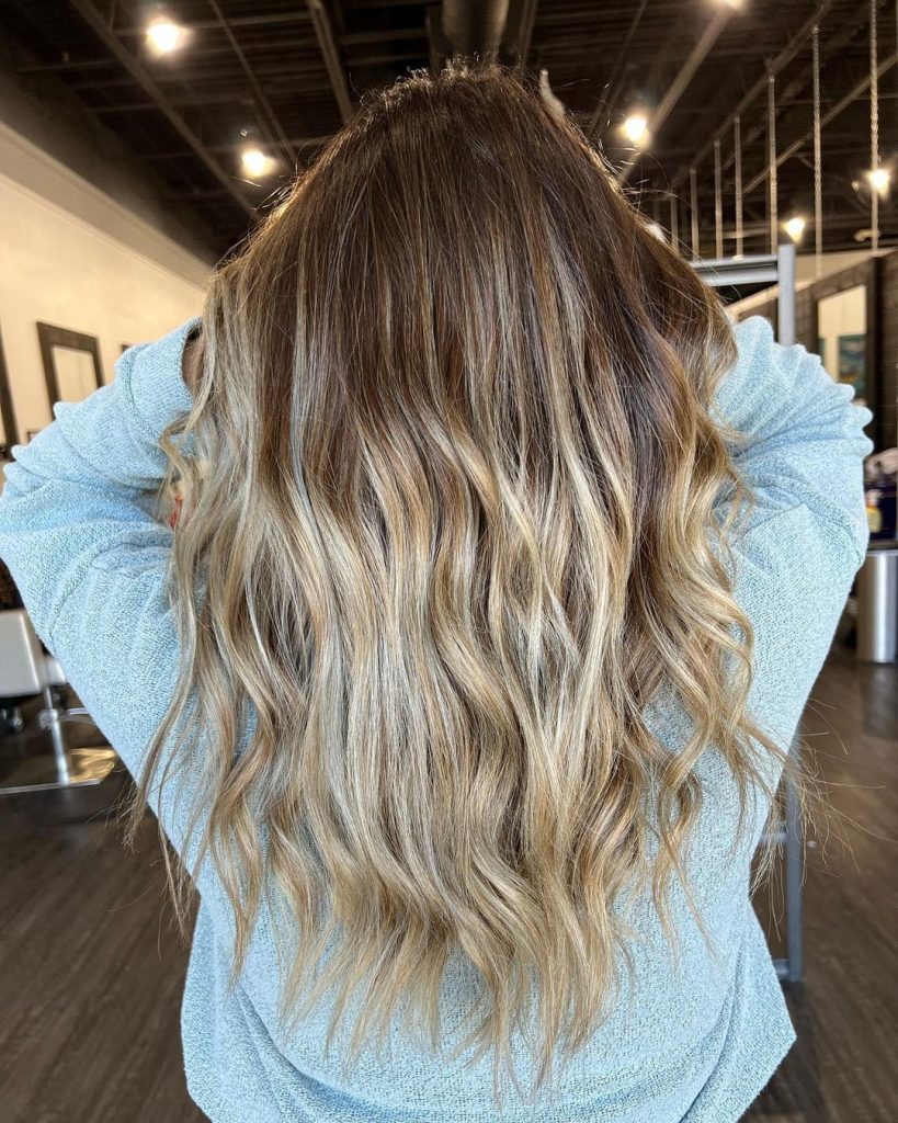 The blonde highlights give this curtain bangs design some awesome vibe