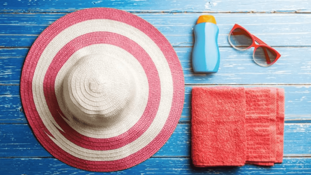 summer hat, red towel, sunglasses and sunscreen