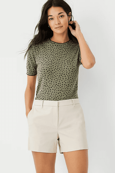 girl wearing black spotted green shirt with beige shorts
