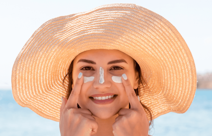 lady wearing summer hat with sunscreen on her face