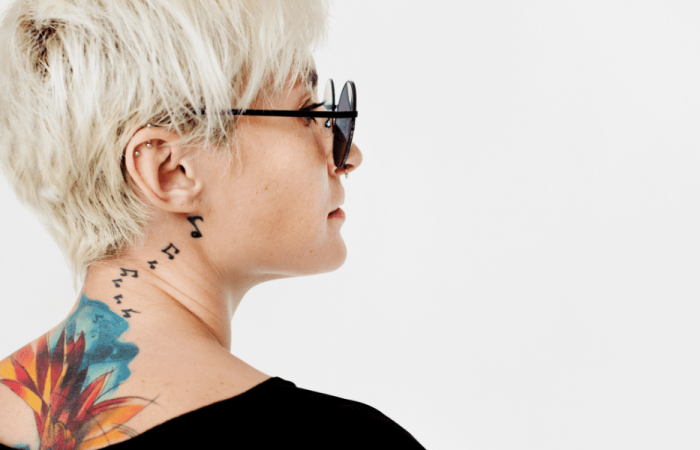 beautiful woman with music notes tattoo behind her ear